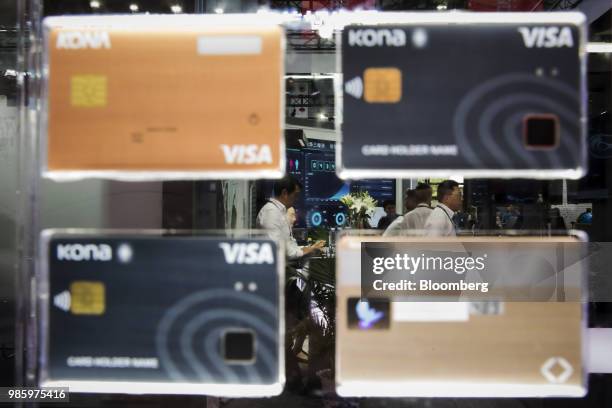 Attendees stand beyond a display of Visa Inc. Biometric credit cards manufactured by Kona I Co. At the Mobile World Congress Shanghai in Shanghai,...