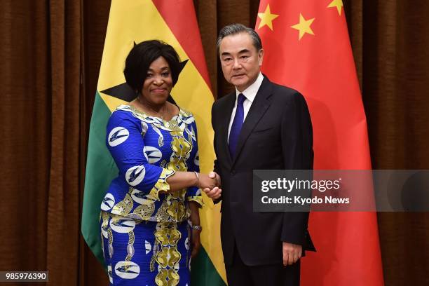 File photo taken on June 11 shows Chinese Foreign Minister Wang Yi shaking hands with his Ghana counterpart Shirley Botchwey ahead of their talks in...
