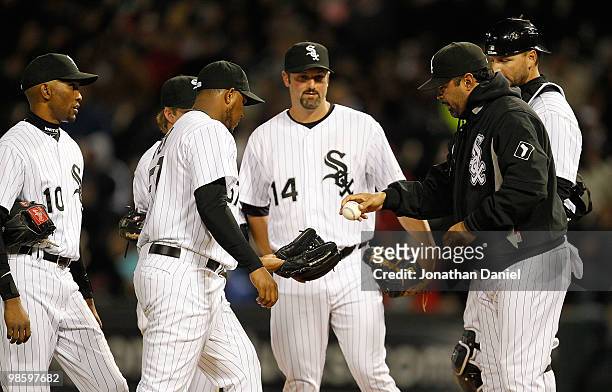 Manager Ozzie Guillen of the Chicago White Sox gives the ball to relief pitcher Tony Pena as teammates Alexei Ramirez, Paul Konerko and A.J....
