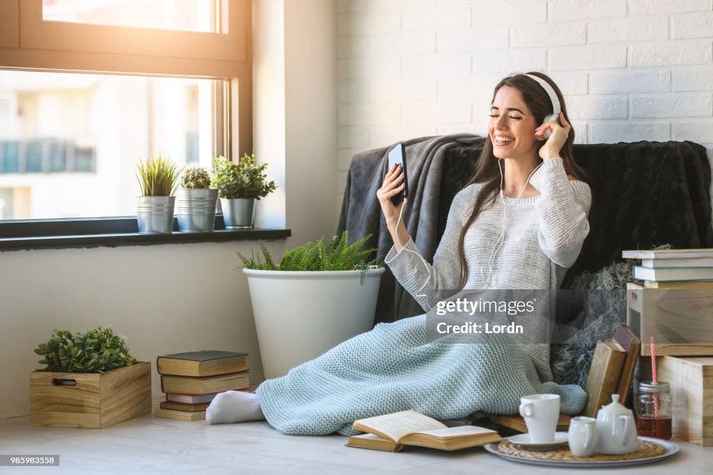 Bella giovane donna a casa ama ascoltare musica