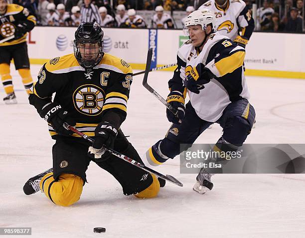 Zdeno Chara of the Boston Bruins tries to keep the puck as Toni Lydman of the Buffalo Sabres defends in Game Four of the Eastern Conference...
