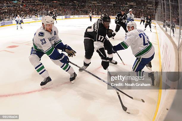 Wayne Simmonds of the Los Angeles Kings battles for the puck against Henrik Sedin and Alexander Edler of the Vancouver Canucks in Game Four of the...