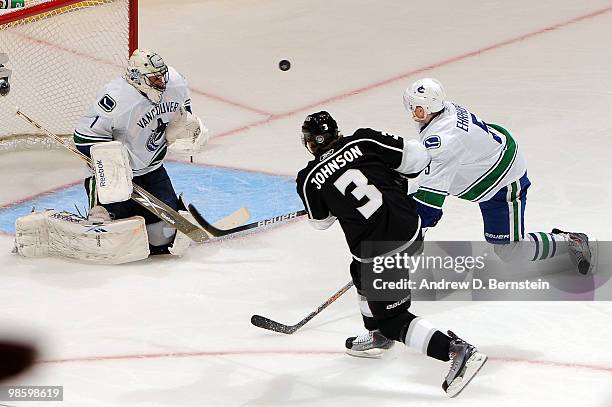 Jack Johnson of the Los Angeles Kings takes a shot against Christian Ehrhoff and Roberto Luongo of the Vancouver Canucks in Game Four of the Western...