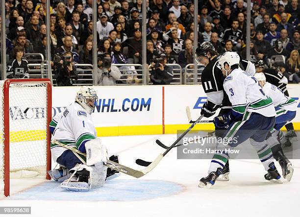 Anze Kopitar of the Los Angeles Kings redirects the puck for a goal in front of Roberto Luongo and Kevin Bieksa of the Vancouver Canucks for a 3-2...