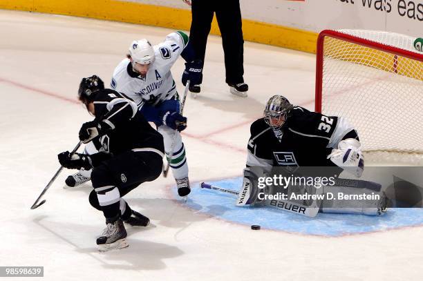 Jonathan Quick of the Los Angeles Kings reaches for the puck as teammate Drew Doughty battles for position against Ryan Kesler of the Vancouver...