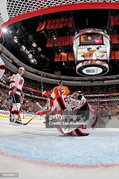 Martin Brodeur and Colin White of the New Jersey Devils look at the puck in the net as Jeff Carter and Kimmo Timonen of the Philadelphia Flyers...