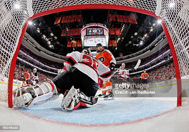 Martin Brodeur of the New Jersey Devils makes a save as teammates Mike Mottau, Colin White and Scott Hartnell of the Philadelphia Flyers wait for a...