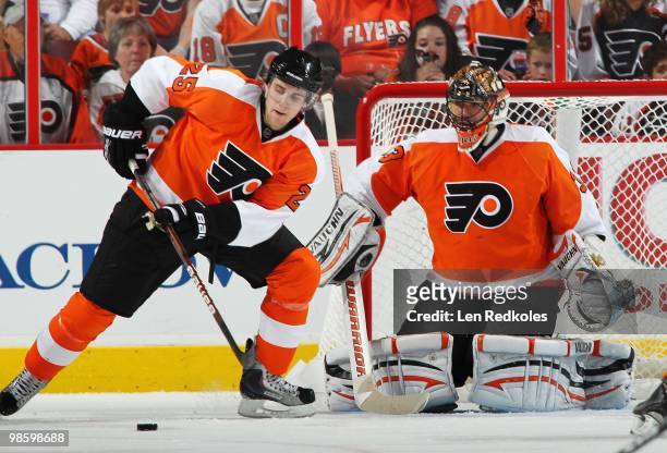 Matt Carle of the Philadelphia Flyers plays the puck in front of teammate Brian Boucher against the New Jersey Devils in Game Four of the Eastern...