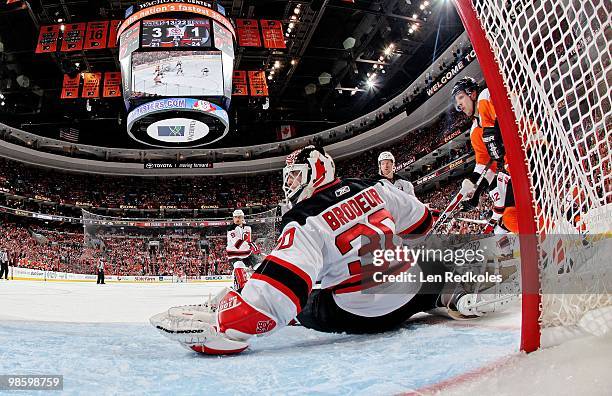 Martin Brodeur of the New Jersey Devils makes a glove save as Danny Briere of the Philadelphia Flyers waits for a rebound in Game Four of the Eastern...