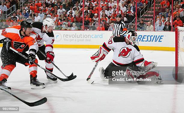 Paul Martin and Martin Brodeur of the New Jersey Devils stop a shot on goal by Darroll Powe of the Philadelphia Flyers in Game Four of the Eastern...