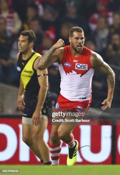 Lance Franklin of the Swans celebrates after kicking a goal as Alex Rance of the Tigers looks on during the round 15 AFL match between the Richmond...