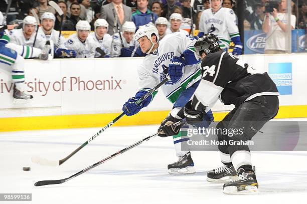 Kevin Bieska of the Vancouver Canucks skates with the puck against Alexander Frolov of the Los Angeles Kings in Game Four of the Western Conference...