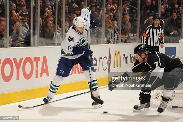 Ryan Kesler of the Vancouver Canucks reaches for the puck against Rob Scuderi of the Los Angeles Kings in Game Four of the Western Conference...