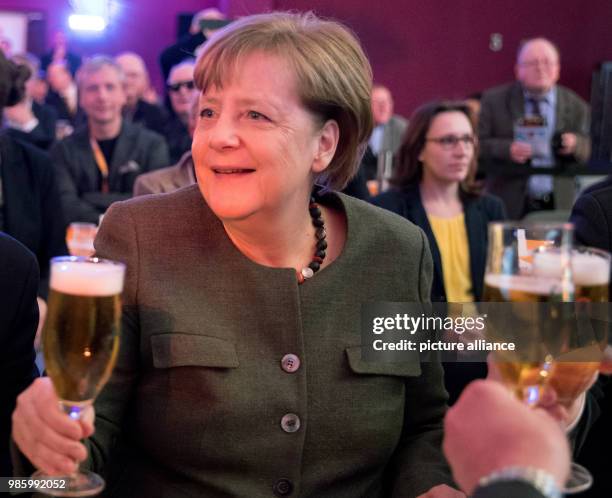 German Chancellor and chairwoman of the Christian Democratic Union , Angela Merkel smiles as she toasts with a glass of beer during the traditional...
