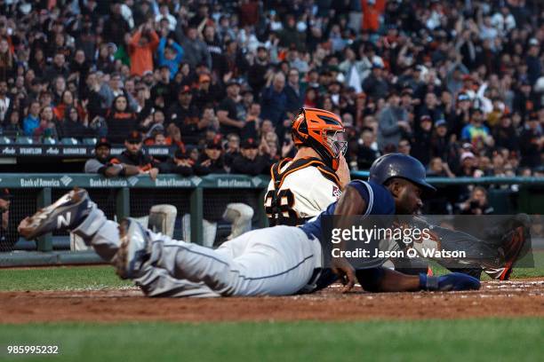 Jose Pirela of the San Diego Padres is tagged out at home plate by Buster Posey of the San Francisco Giants during the fifth inning at AT&T Park on...