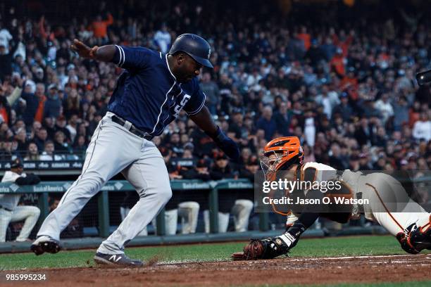 Jose Pirela of the San Diego Padres is tagged out at home plate by Buster Posey of the San Francisco Giants during the fifth inning at AT&T Park on...