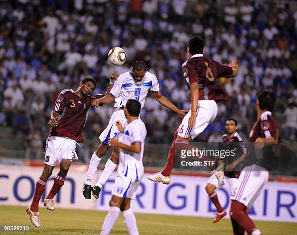 Honduran Jerry Bengtson vies for the ball and Venezuela's Jose Granados and Diacomo Digiorge during the match between the national soccer teams of...