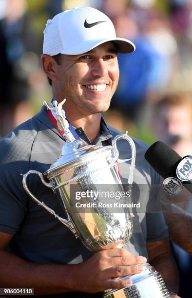 Brooks Koepka of the United States celebrates with the winners trophy after the final round of the 2018 U.S. Open at Shinnecock Hills Golf Club on...