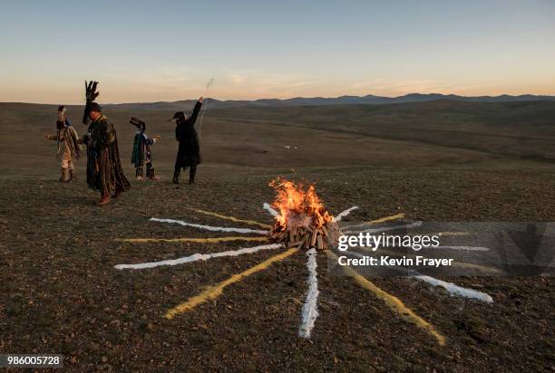 Mongolian Shamans or Buu, make offerings as they take part in a sun ritual ceremony to mark the period of the Summer Solstice in the grasslands on...