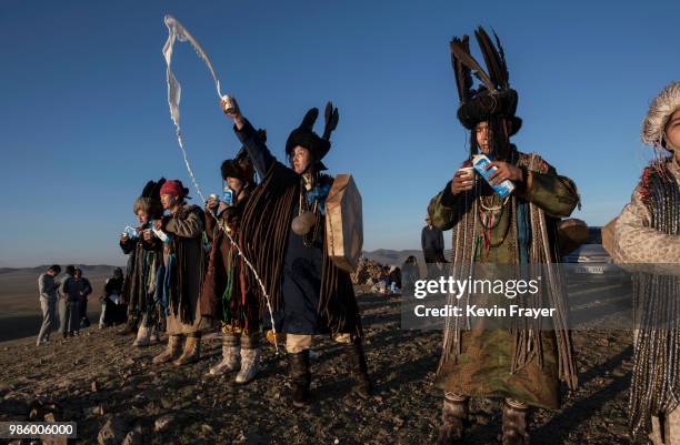 Mongolian Shamans or Buu, throw milk as an offering during a sun ritual ceremony to mark the period of the Summer Solstice in the grasslands at...