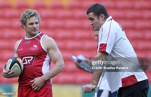 Peter Hynes chats with injured team mate James Horwill during the Reds Super 14 training session at Suncorp Stadium on April 22, 2010 in Brisbane,...