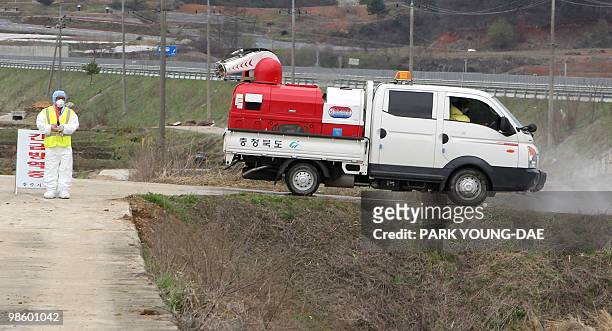 South Korean health official stands on guard at the entrace of a farm in Chungju, 147 kilometres south of Seoul on April 22, 2010. South Korea's...