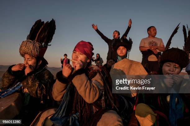 Mongolian Shamans or Buu, play the south harp as they sit together while taking part in a sun ritual ceremony to mark the period of the Summer...