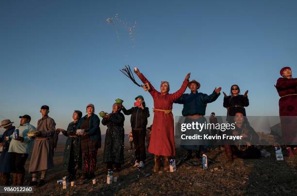 Mongolian Shamans or Buu,and their followers throw milk as an offering during a sun ritual ceremony to mark the period of the Summer Solstice in the...