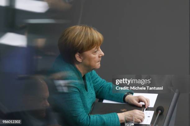 German Chancellor Angela Merkel sits down by Finance Minister and vice Chancellor, Olaf Scholz after she gave a government declaration at the...