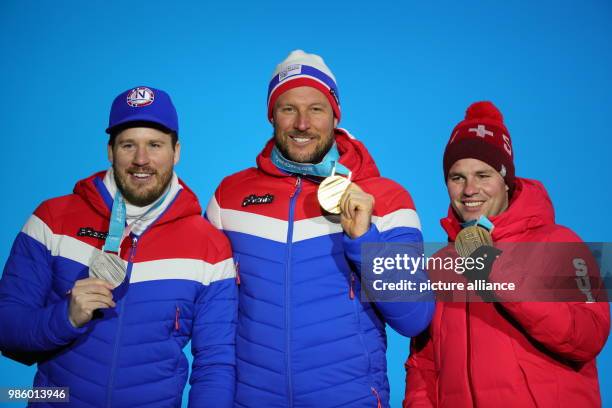 Norway's Kjetil Jansrud , Norway's Aksel Lund Svindal and Switzerland's Beat Feuz celebrate during the award ceremony after the men's alpine skiing...