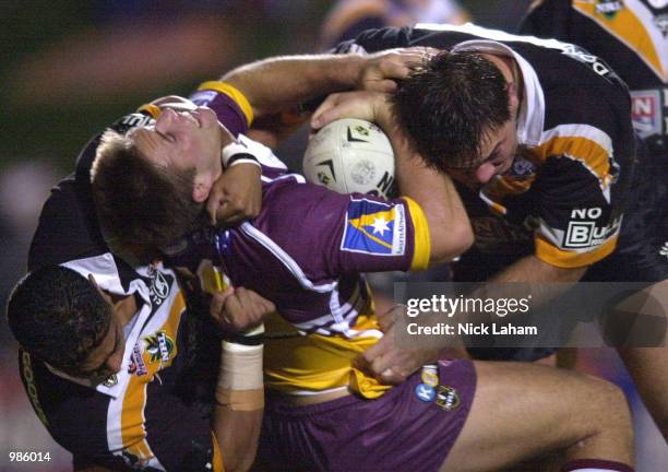 Dane Carlaw of the Broncos is tackled by the Tigers defence during the round 17 NRL match between the Wests Tigers and the Brisbane Broncos held at...