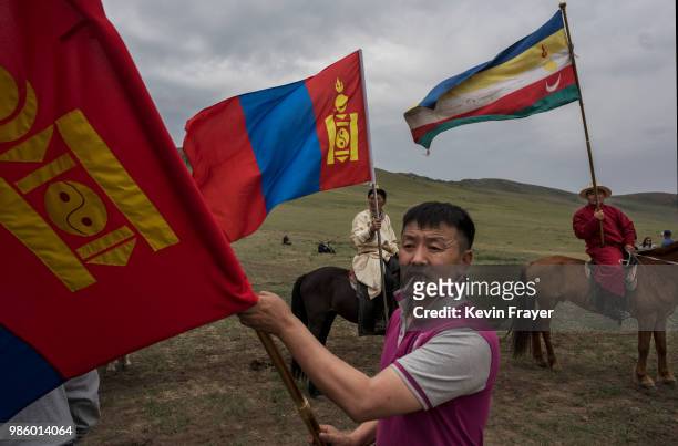 Mongolian followers of Shamanis or Buu Murgal, carry flags before a fire ritual meant to summon spirits to mark the period of the Summer Solstice on...