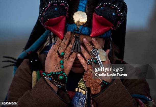 Mongolian Shaman or Buu, prays during a sun ritual ceremony to mark the period of the Summer Solstice in the grasslands at sunrise on June 22, 2018...
