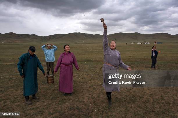 Mongolian followers of Shamanism or Buu murgul, throw milk during a blessing as part of a Zugel ritual ceremony in the grasslands on June 21, 2018...