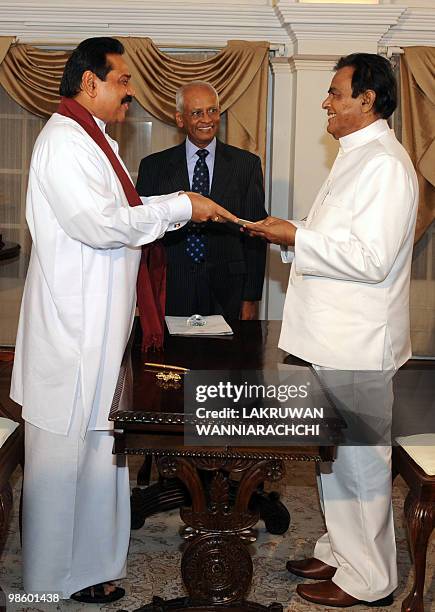 Sri Lankan President Mahinda Rajapakse administers the oath of office to the new Sri Lankan Prime Minister D. M. Jayaratne in Colombo on April 20,...