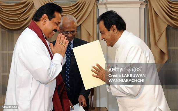 Sri Lankan President Mahinda Rajapakse administers the oath of office to the new Sri Lankan Prime Minister D. M. Jayaratne in Colombo on April 21,...