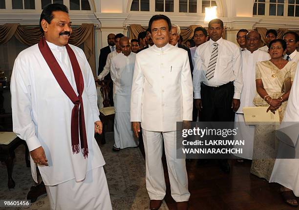 New Sri Lankan Prime Minister D. M. Jayaratne poses alongside President Mahinda Rajapakse after a swearing in ceremony in Colombo on April 21, 2010....