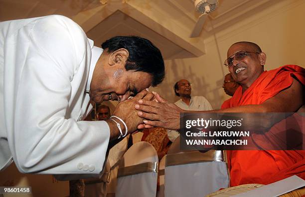 New Sri Lankan Prime Minister D. M. Jayaratne receives blessings from a Buddhist monk during a swearing in ceremony in Colombo on April 21, 2010. Sri...