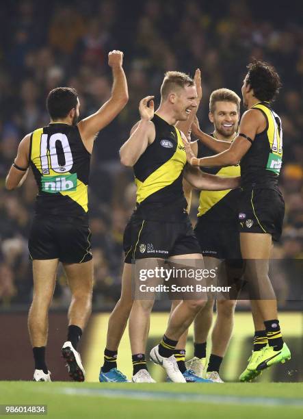 Jack Riewoldt of the Tigers is congratulated by his teammates after kicking a goal during the round 15 AFL match between the Richmond Tigers and the...