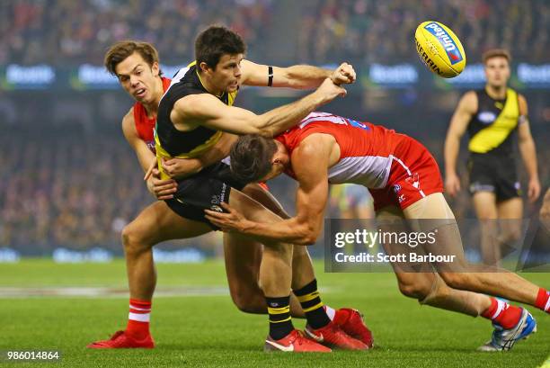 Trent Cotchin of the Tigers is tackled during the round 15 AFL match between the Richmond Tigers and the Sydney Swans at Etihad Stadium on June 28,...