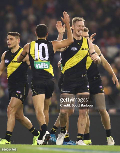 Jack Riewoldt of the Tigers is congratulated by his teammates after kicking a goal during the round 15 AFL match between the Richmond Tigers and the...