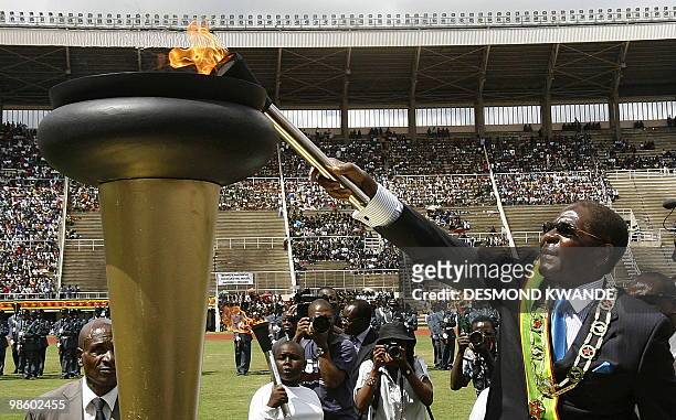 Zimbabwean President Robert Mugabe lights the independence flame at Harare National Stadium during celebrations of Zimbabwe's 30 years of...
