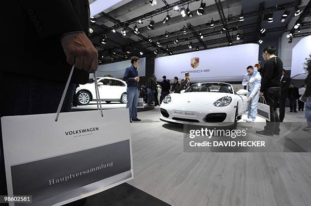 Shareholders inspect a Porsche Boxster Spyder car during the annual general meeting of German car maker Volkswagen on April 22, 2010 in Hamburg,...