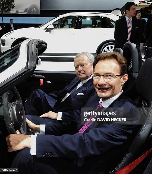 Wolfgang Porsche , board member of German carmaker Volkswagen , and Porsche chairman Michael Macht pose in a Porsche car during VW's annual general...