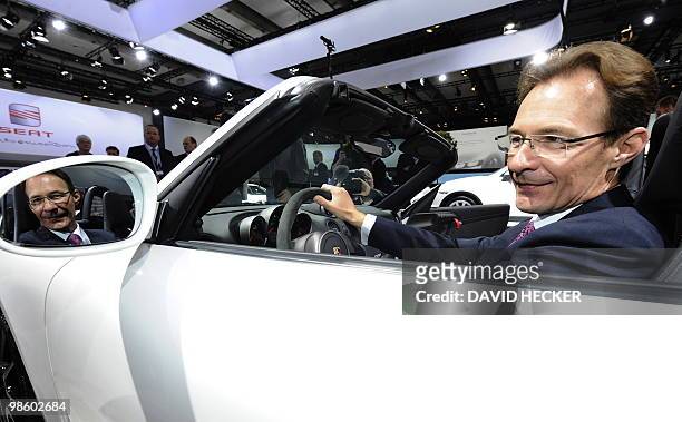 Porsche chairman Michael Macht poses in a Porsche car during the annual general meeting of German carmaker Volkswagen on April 22, 2010 in Hamburg,...