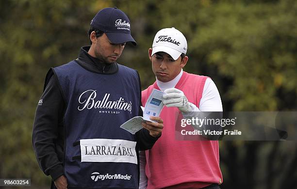 Pablo Larrazabal and his brother and caddie Alejandro Larrazabal of Spain talk on the 14th tee during Round One of the Ballantine's Championship at...