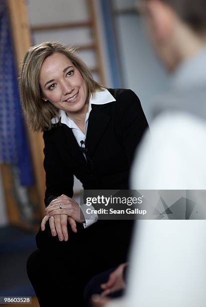 German Family Minister Kristina Schroeder chats with male high school students considering a future in child care during a visit to the Spreekita...