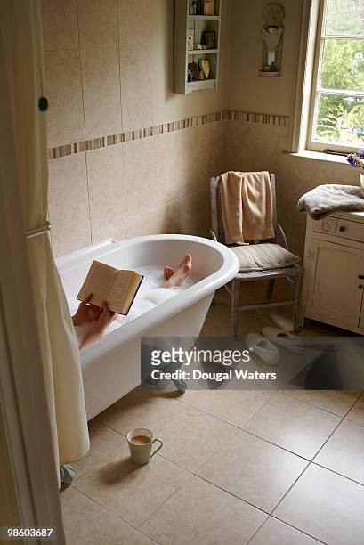 woman in bath reading book. - sapato cor de creme - fotografias e filmes do acervo