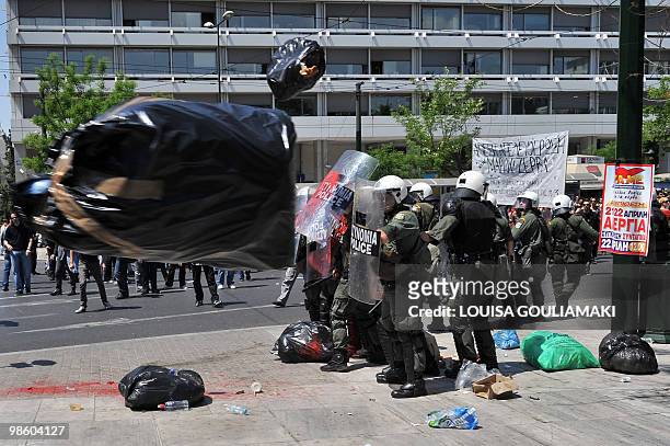 Demonstrators throw bags of rubbish towards riot police outside the Finance ministry during a demonstration in central Athens on April 22, 2010....
