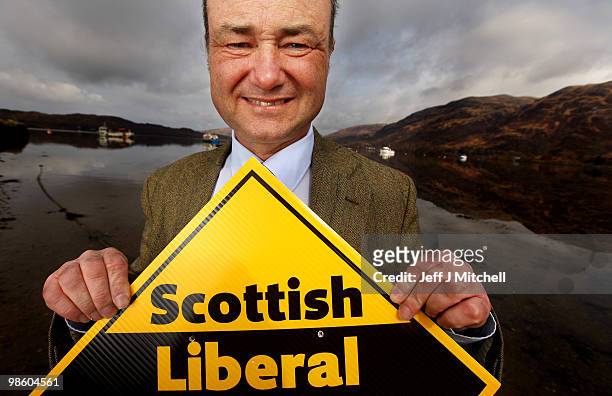 Alan Reid, the Liberal Democrat candidate for Argyll and Bute, holds up a party sign on the shore of Loch Etive on April 21, 2010 in Taynuilt in...